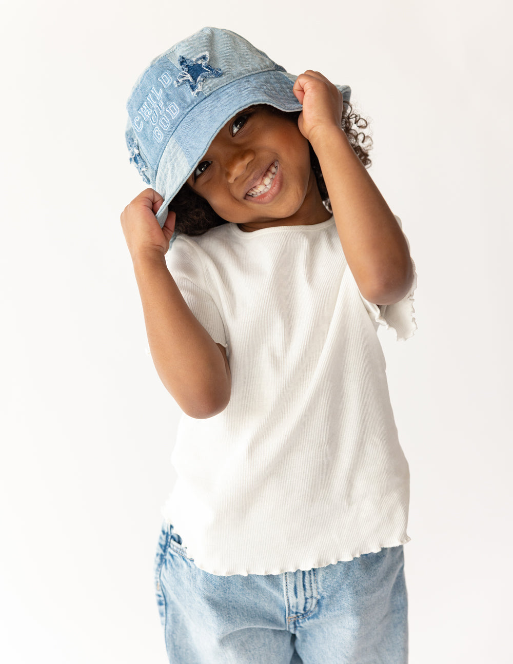 Light blue denim kids bucket hat with front logo, child smiling while wearing
