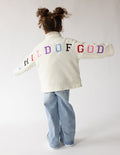 Kids cream fleece pullover with multicolor “CHILD OF GOD” logo on back