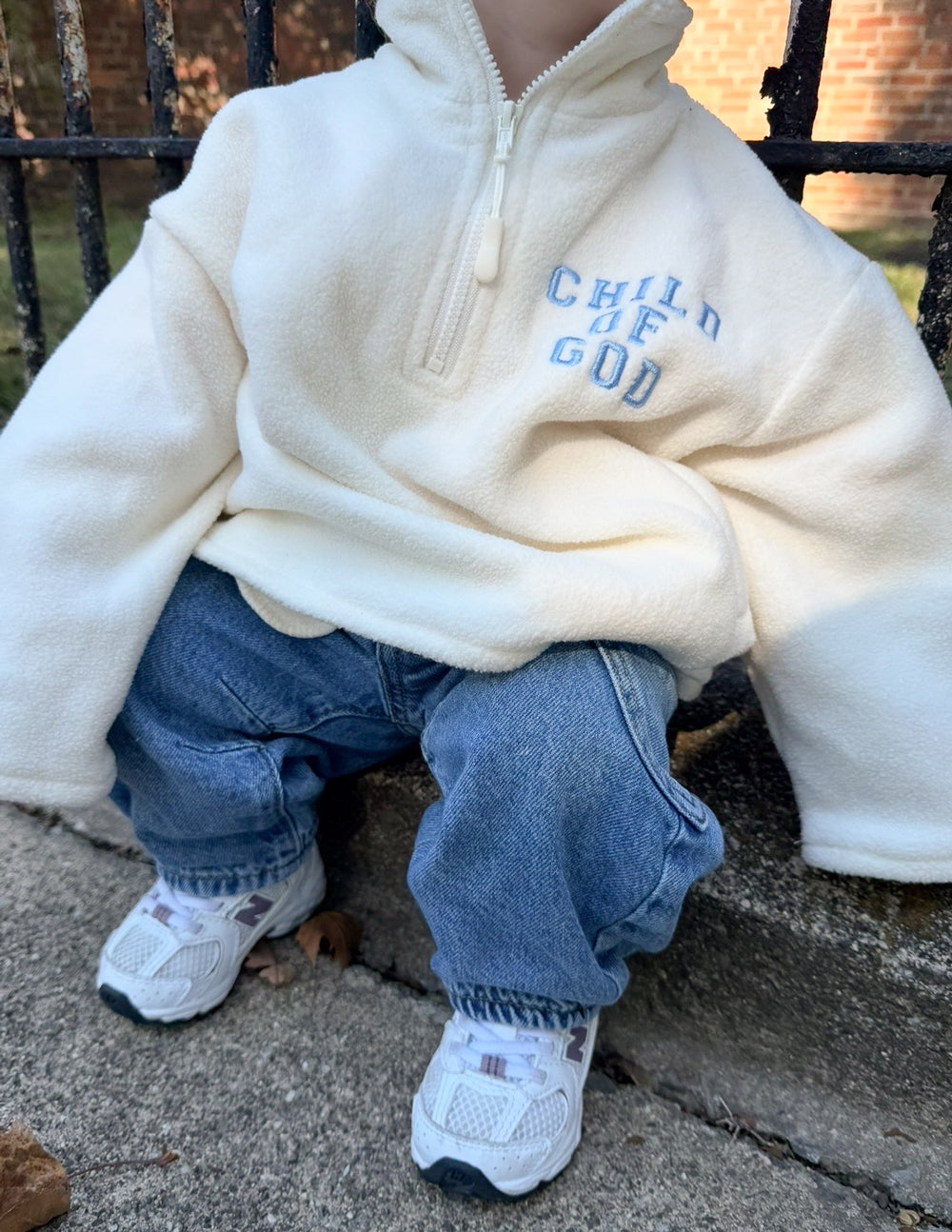 Kids fleece pullover hoodie, off-white quarter-zip with embroidered chest text and pocket