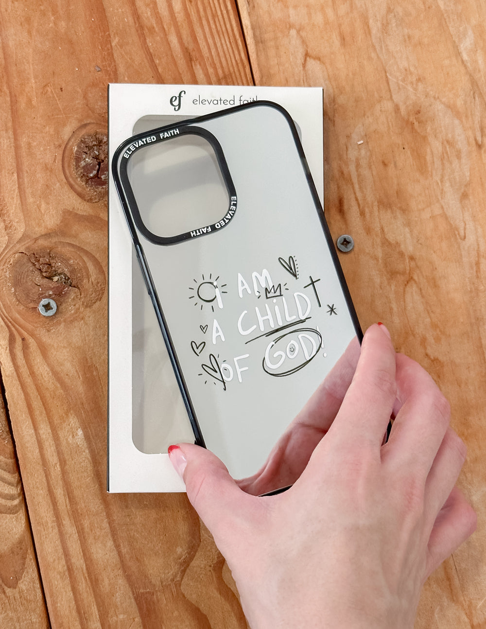Mirror phone case with black trim and "I AM CHILD OF GOD" script on back