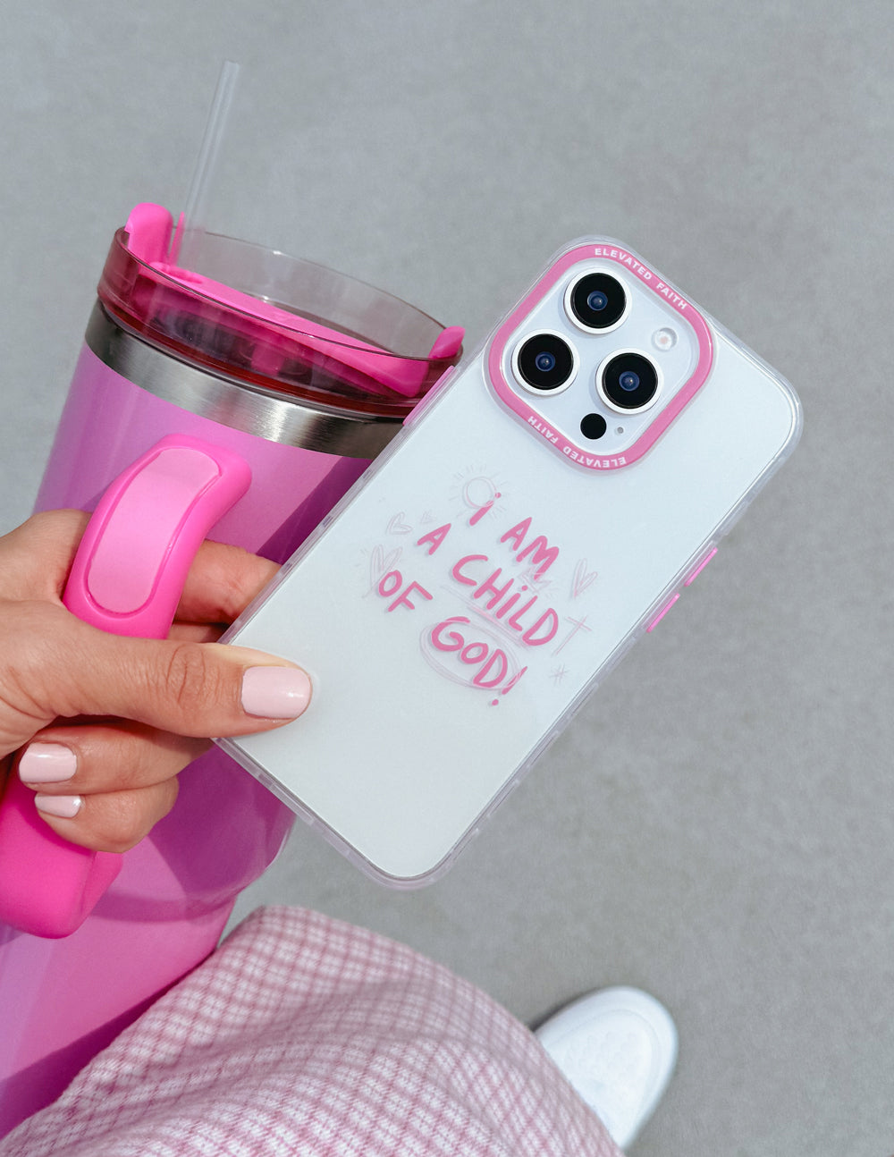 Pink clear phone case angled view with 'I AM A CHILD OF GOD!' lettering and cutouts