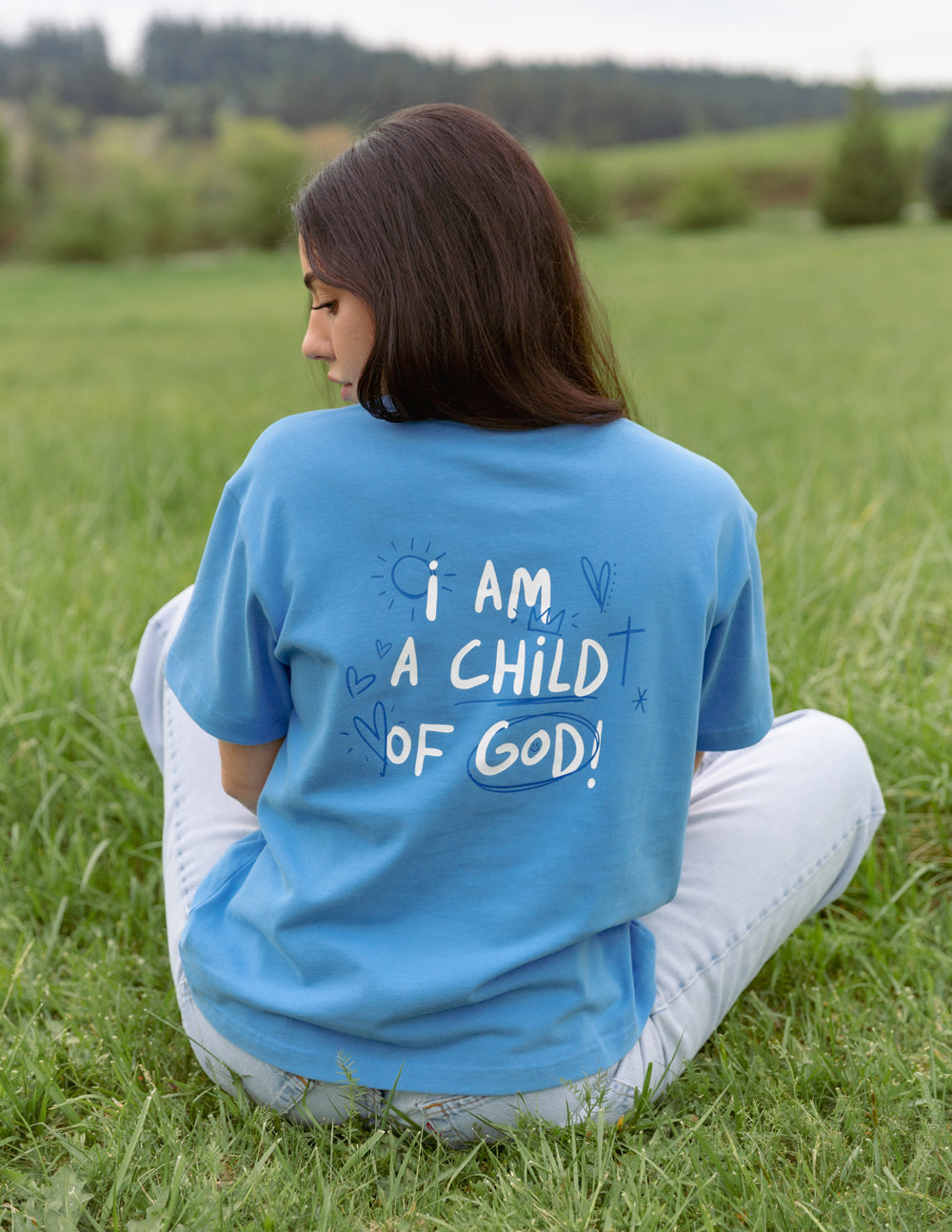 Blue unisex T-shirt viewed from back with “I AM A CHILD OF GOD!” text