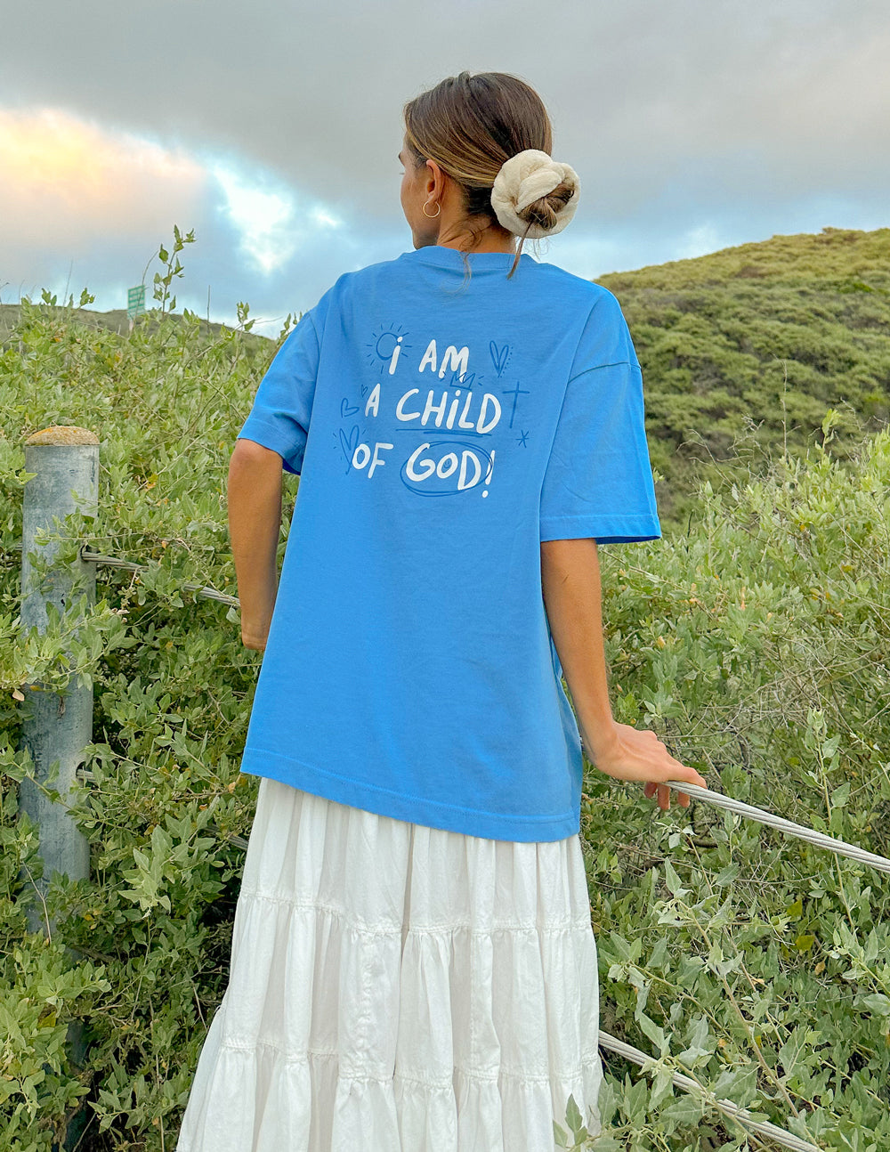 Blue unisex T-shirt viewed from back with “I AM A CHILD OF GOD!” text