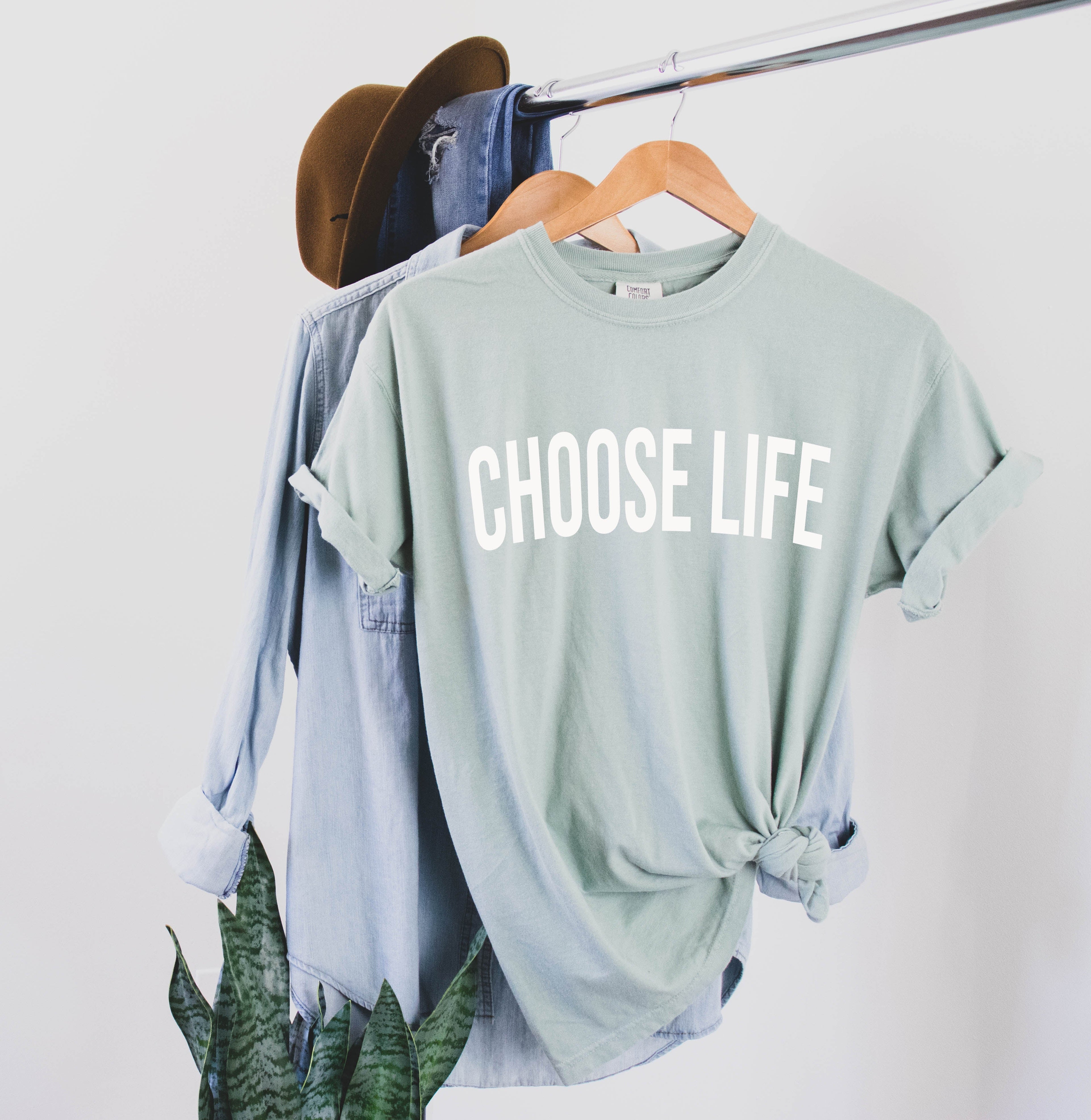 Mint crew-neck T-shirt with 'CHOOSE LIFE' white lettering, front view on hanger