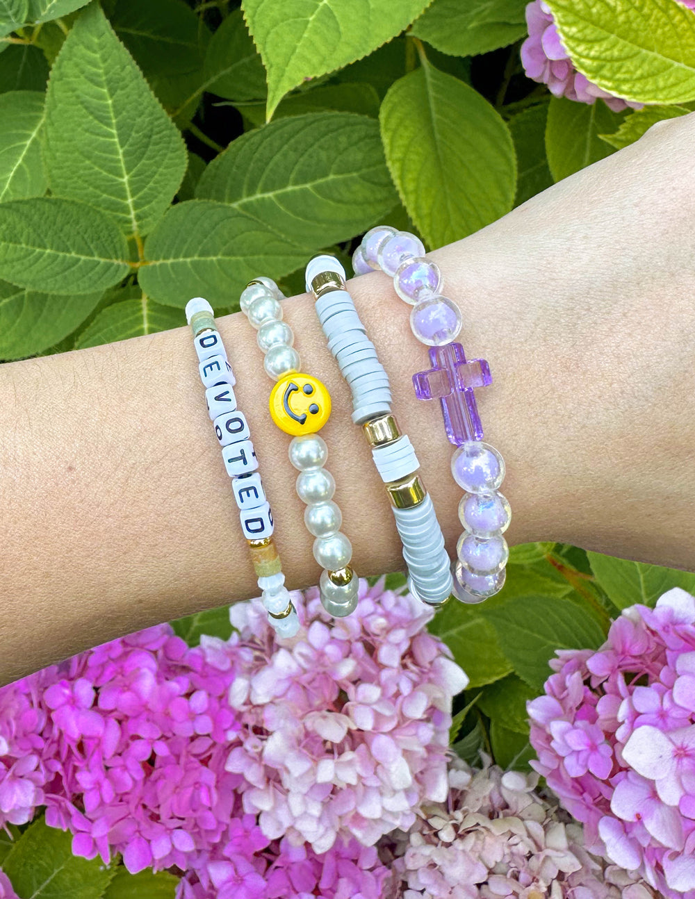Letter bead bracelet with 'DEVOTED' beads, purple cross charm, and pearl accents