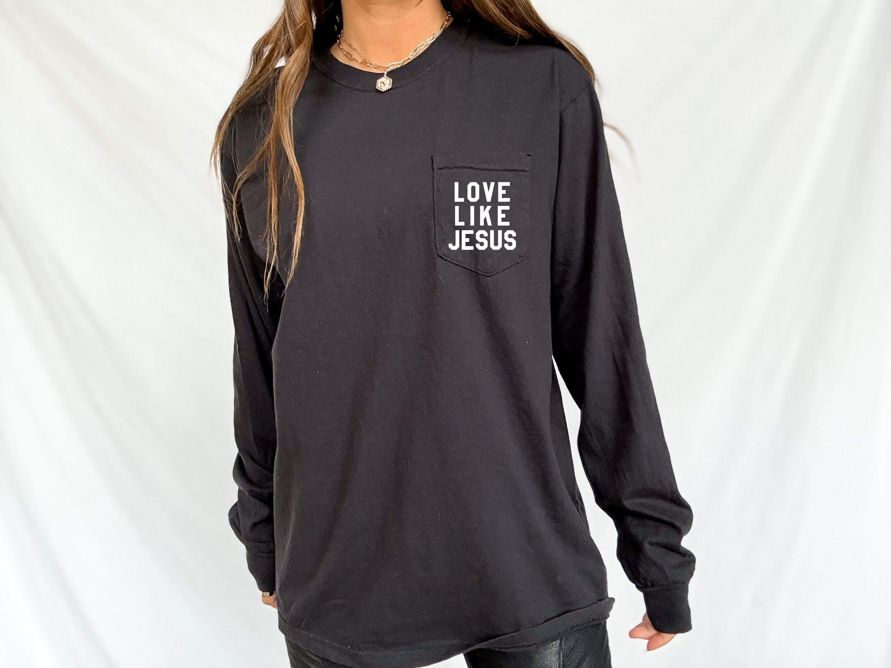 Black long sleeve pocket tee with "LOVE LIKE JESUS" chest print