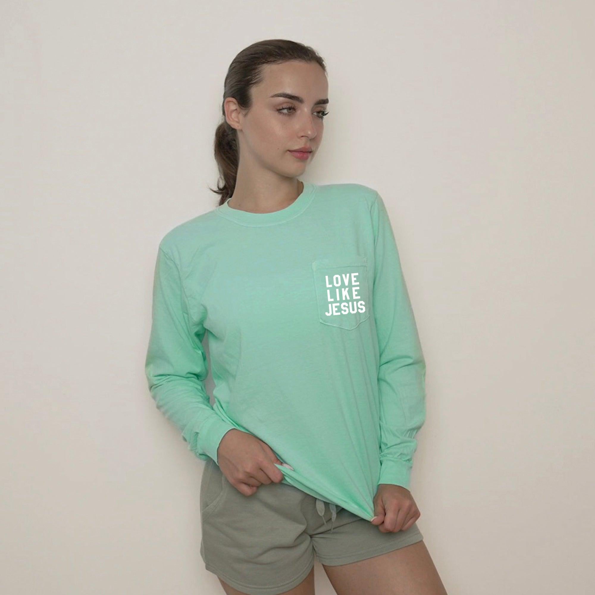 Light green long sleeve pocket tee with "LOVE LIKE JESUS" chest print
