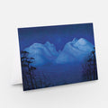 Landscape art print with snowy mountains at night, deep blue sky and silhouetted trees
