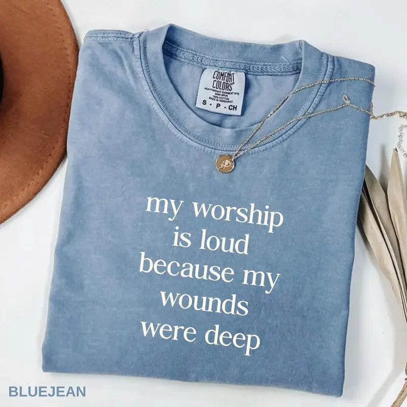 Blue short-sleeve T-shirt with V-neck and necklace; front word graphic in light print