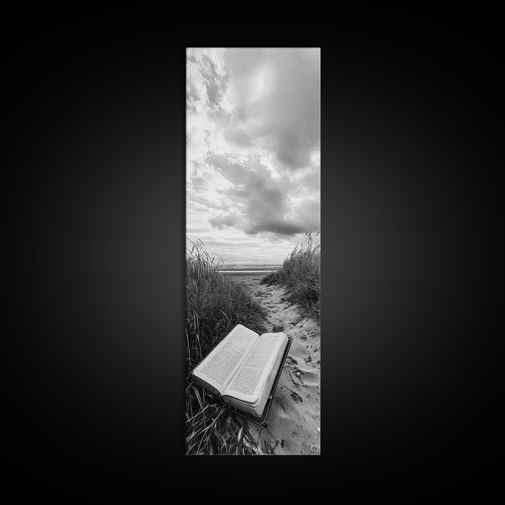 Canvas print of open Bible on a sandy beach path under cloudy sky