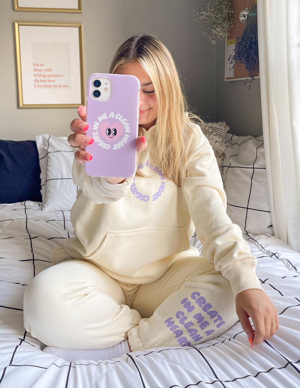 Lilac phone case with alien-face graphic and arched text, held by person