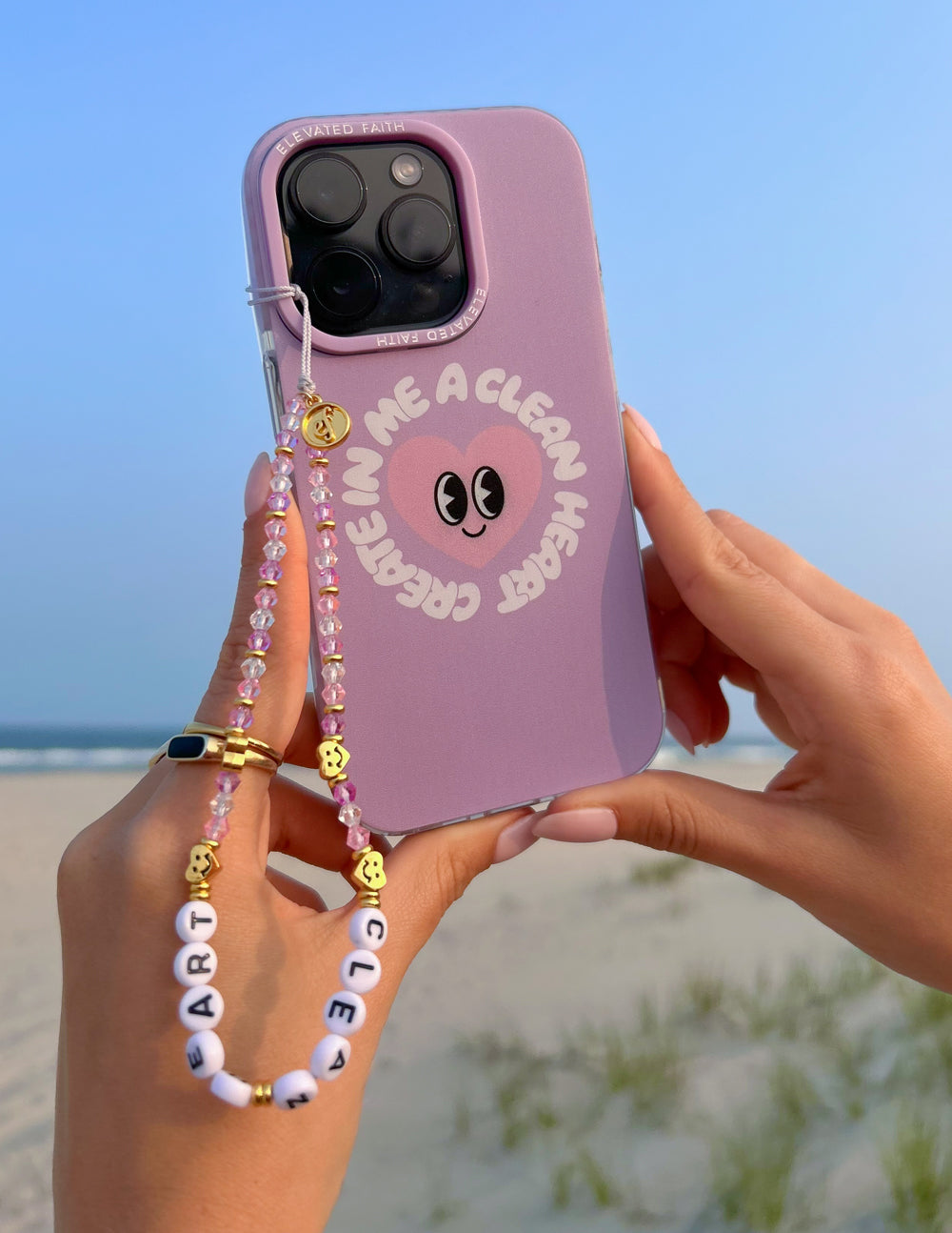 Lilac phone case with alien-face print and beaded wrist strap with gold charms