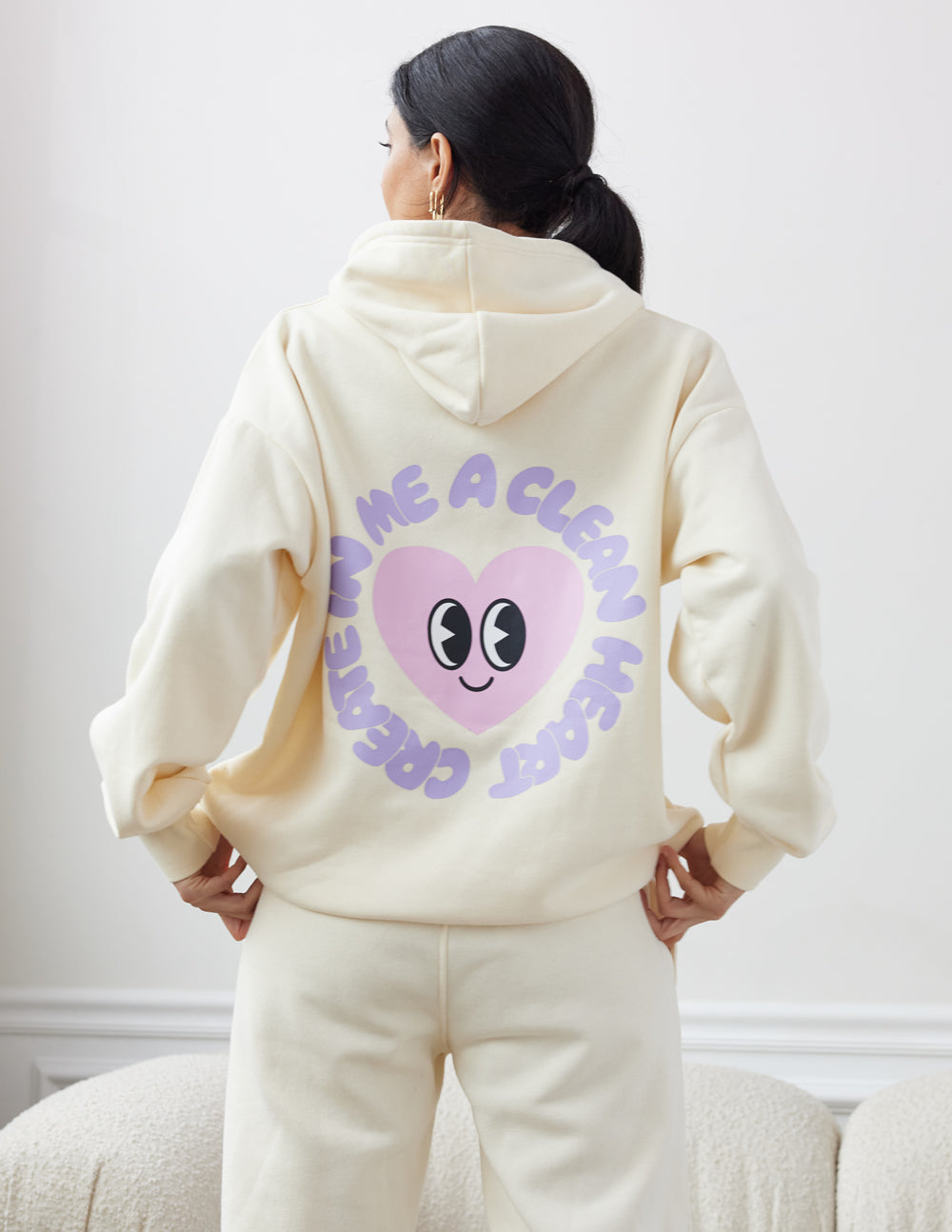 Unisex cream hoodie with purple alien-face graphic on back