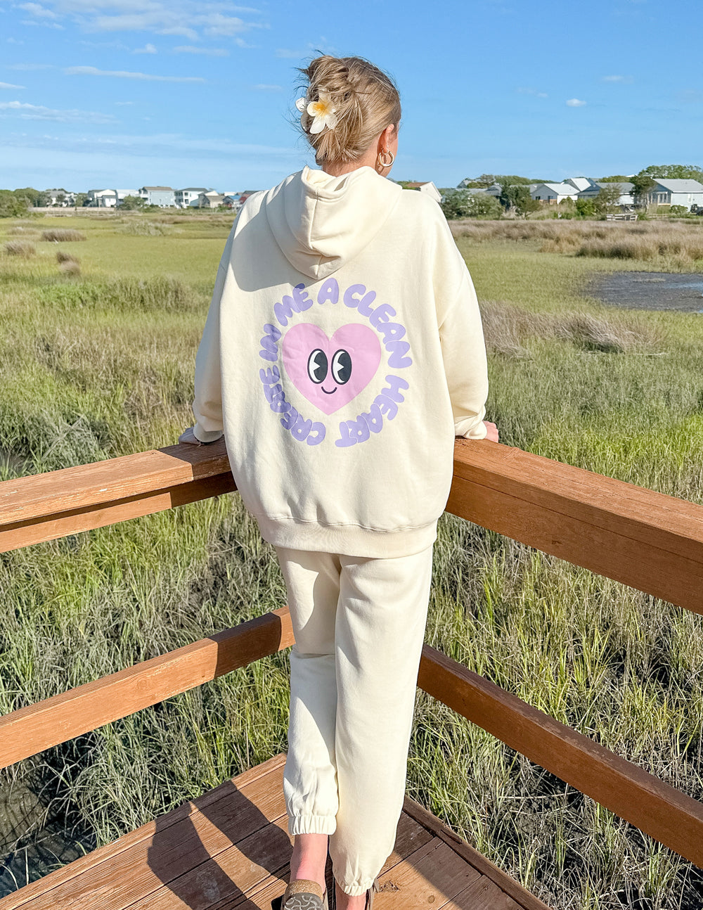 Unisex cream hoodie with purple alien-face back graphic and hood