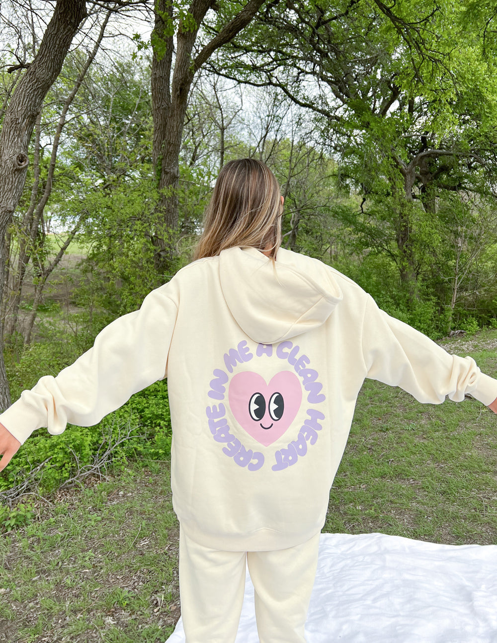 Cream unisex hoodie with purple circular face graphic on back