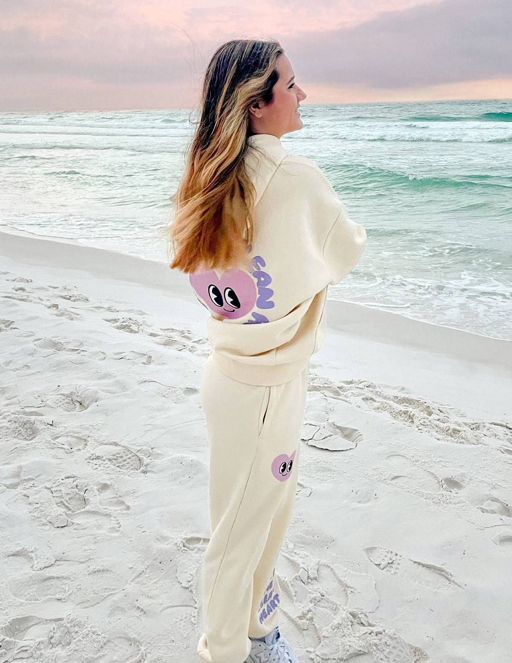 Unisex cream hoodie with purple alien-face back graphic