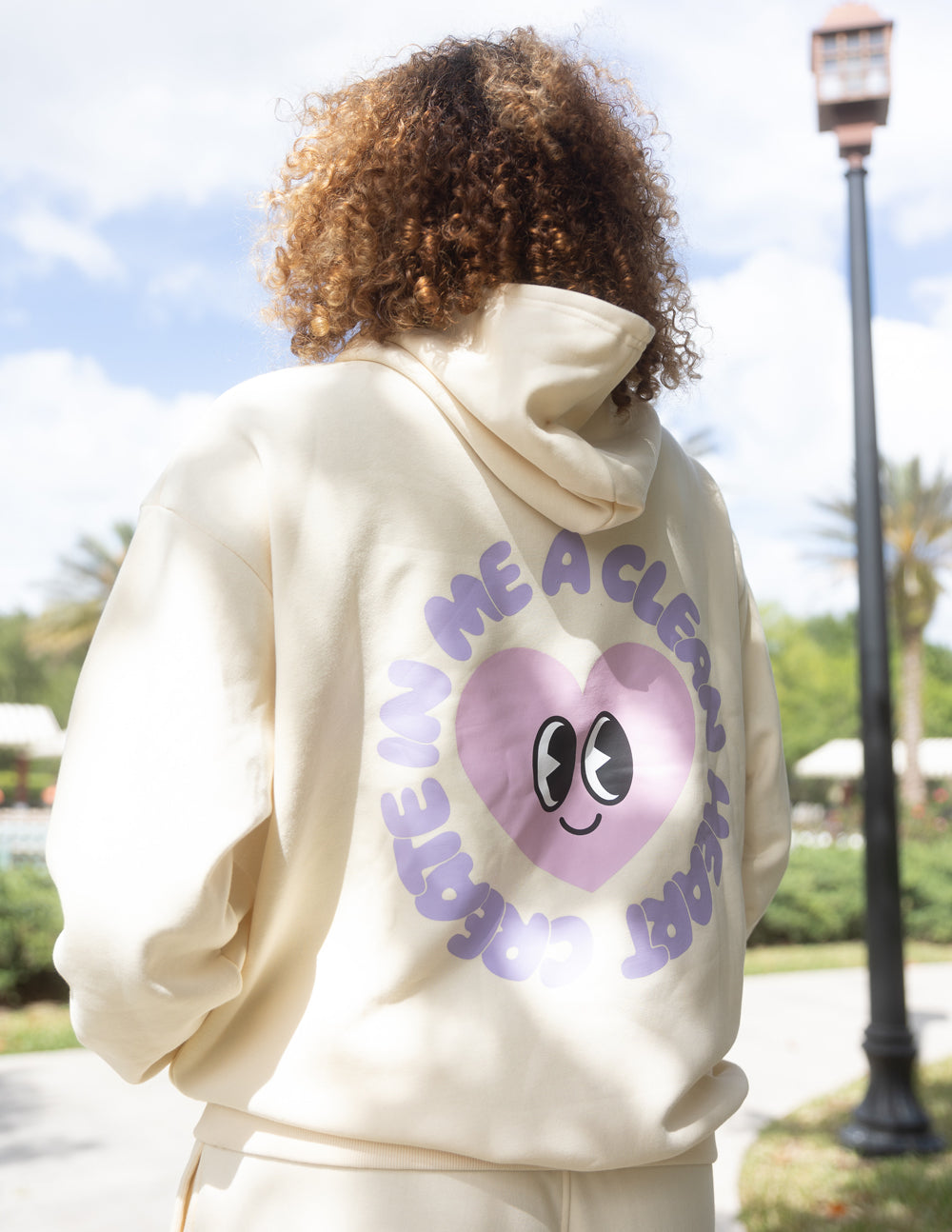 Cream unisex hoodie with purple circular face graphic on back