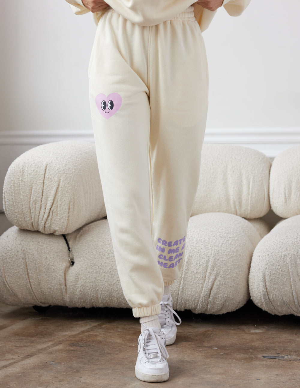 Cream unisex sweatpants with purple heart-face patch and elastic ankle cuffs