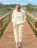 Cream unisex sweatpants with purple heart graphic on leg and cuffed jogger hem