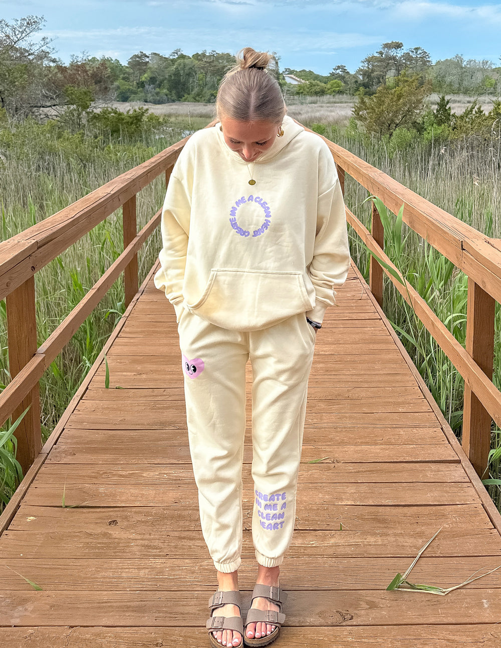 Cream unisex sweatpants with purple heart graphic on leg and cuffed jogger hem