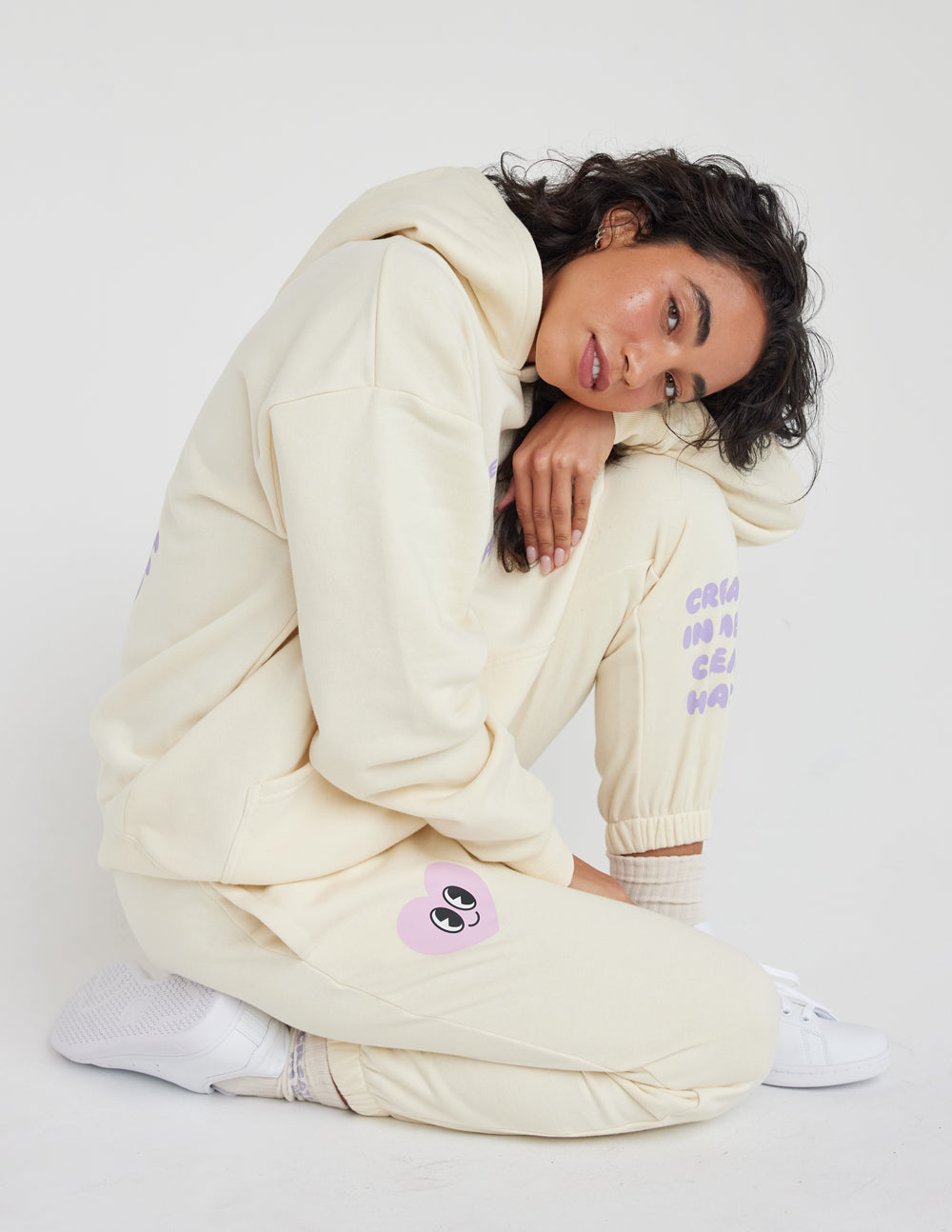 Cream unisex sweatpants with purple heart-face patch on knee and relaxed jogger