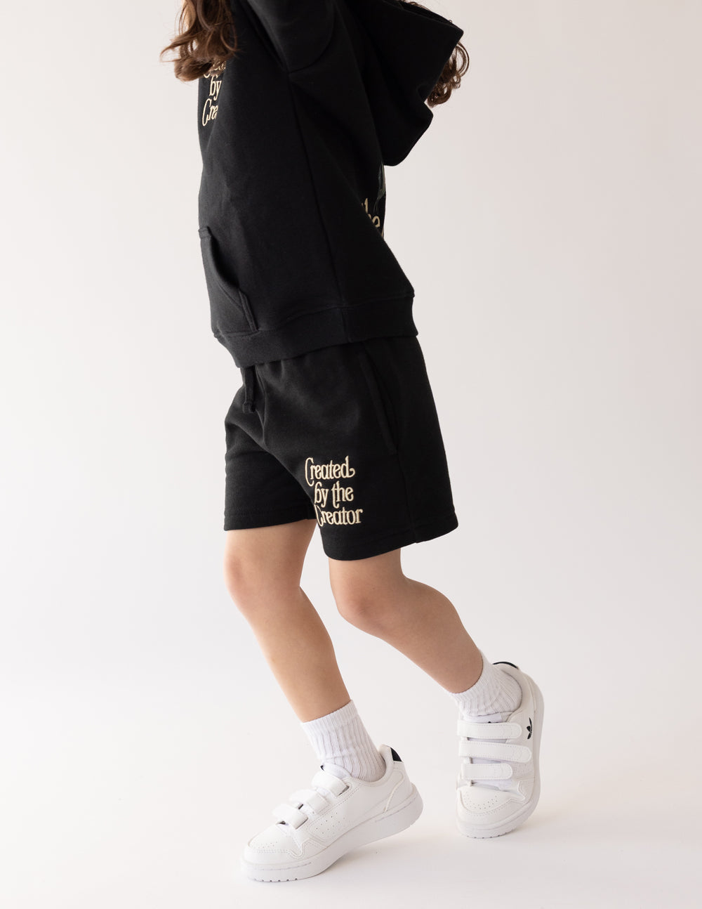 Kids dark shorts with drawstring waist and Created by the Creator logo, side view