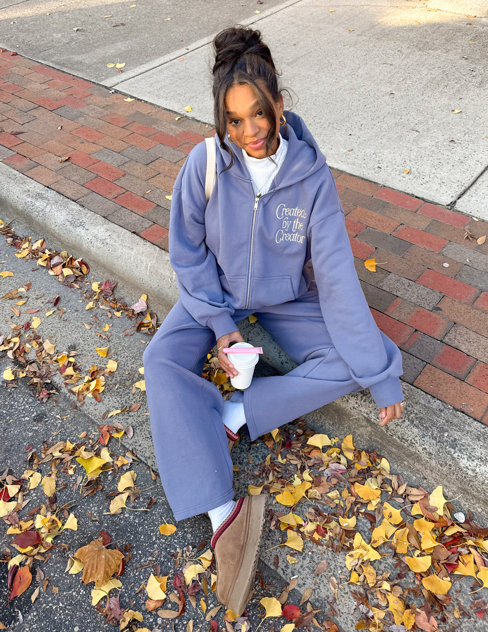 Lavender full-zip hoodie with front zip and logo, worn seated