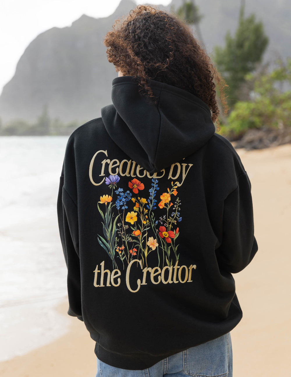 Black unisex hoodie back view with floral 'Created by the Creator' print