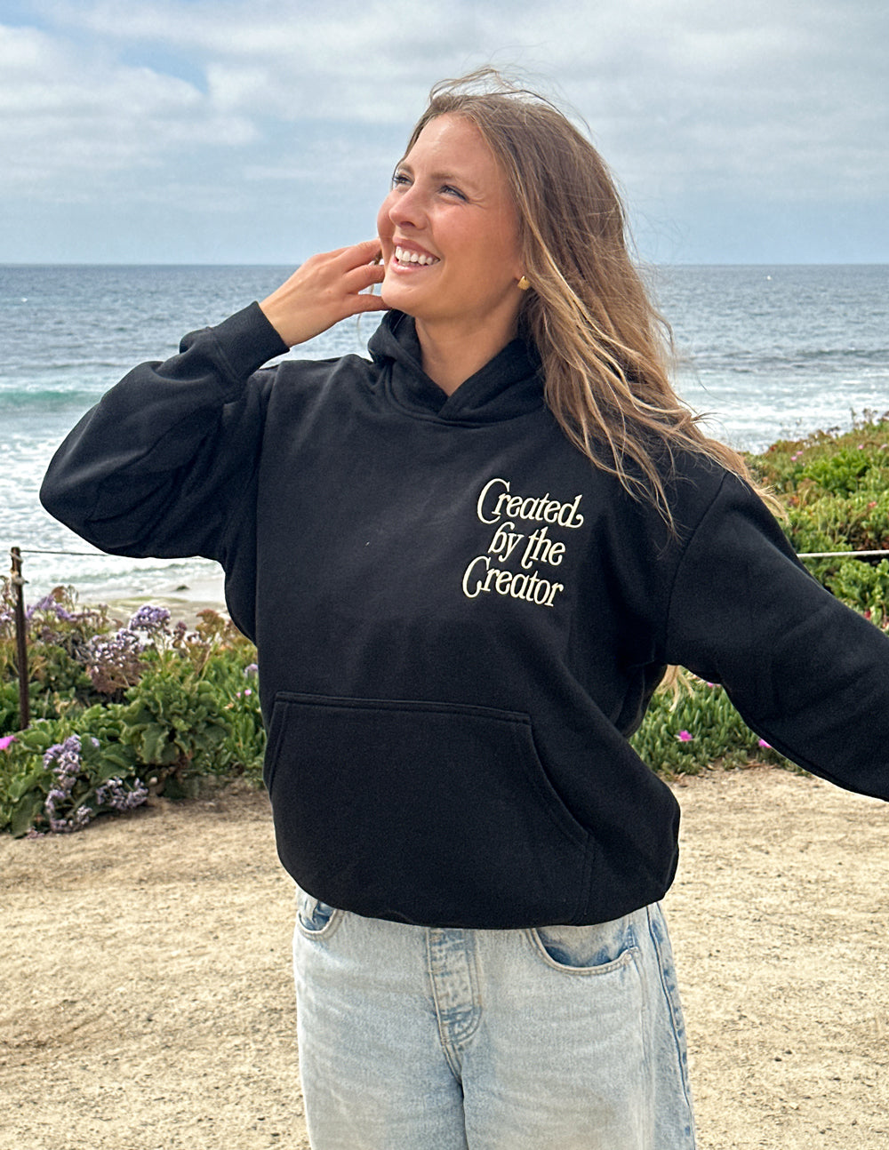 Black unisex hoodie front view with hood down and 'Created by the Creator' chest graphic