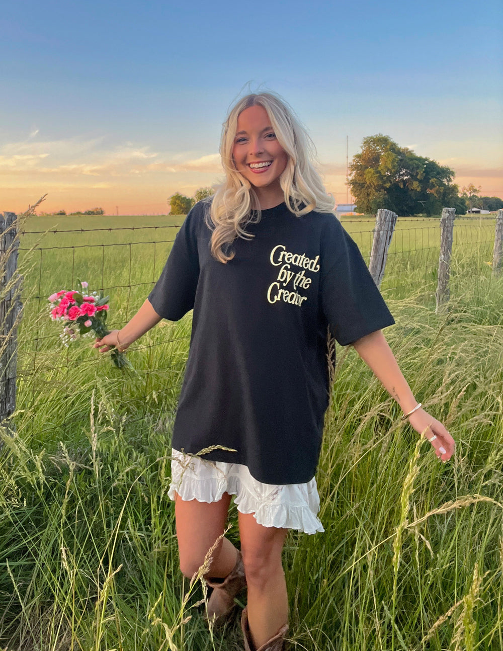 Black unisex tee with front graphic text and small floral design