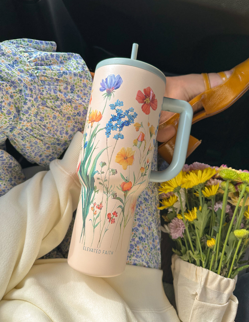 Floral 40 oz tumbler with gray handle and straw lid, angled view