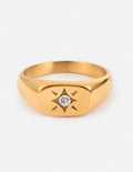 Gold signet ring with starburst motif and clear diamond center