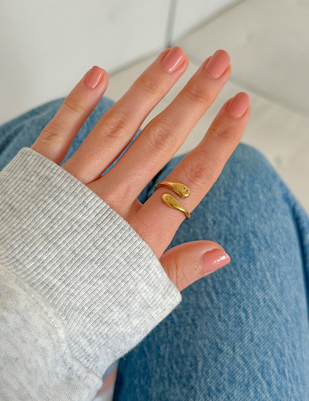 Gold-tone open band ring with heart emblem and cross detail on shank