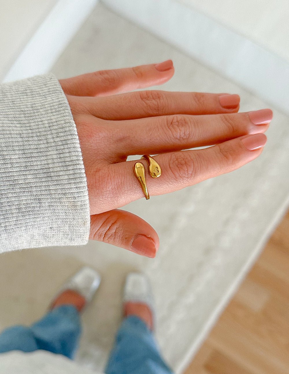 Gold-tone open ring with heart and cross charms, worn on finger