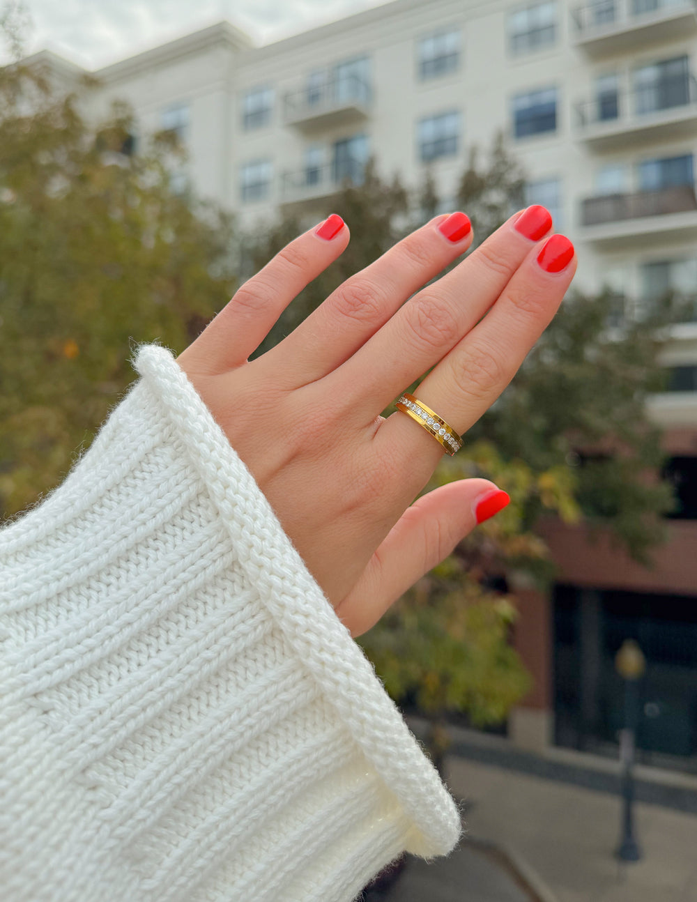 Gold cross gem ring with clear stone accents on a slim band
