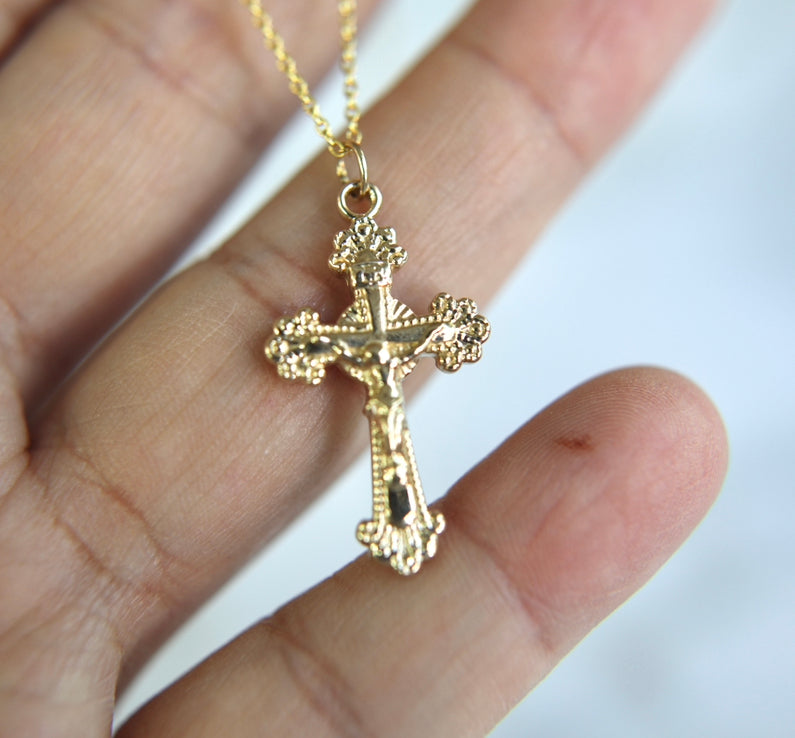 14k gold crucifix pendant on a chain, front cross charm with round details.