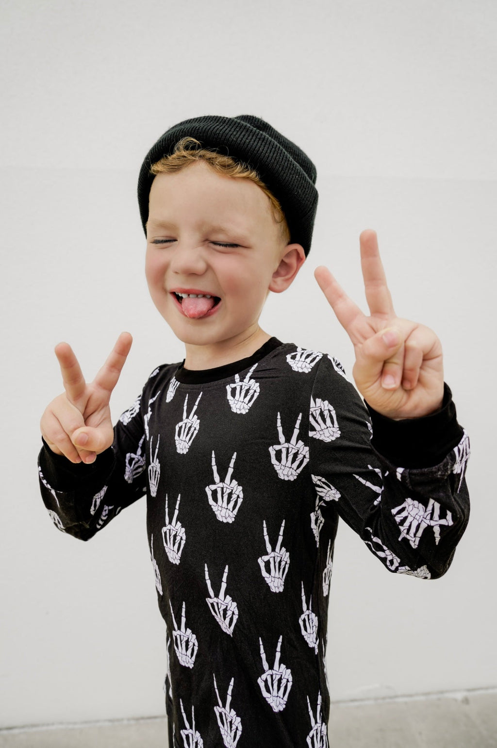 Kids black long-sleeve pajama set with white skeleton-hand print.