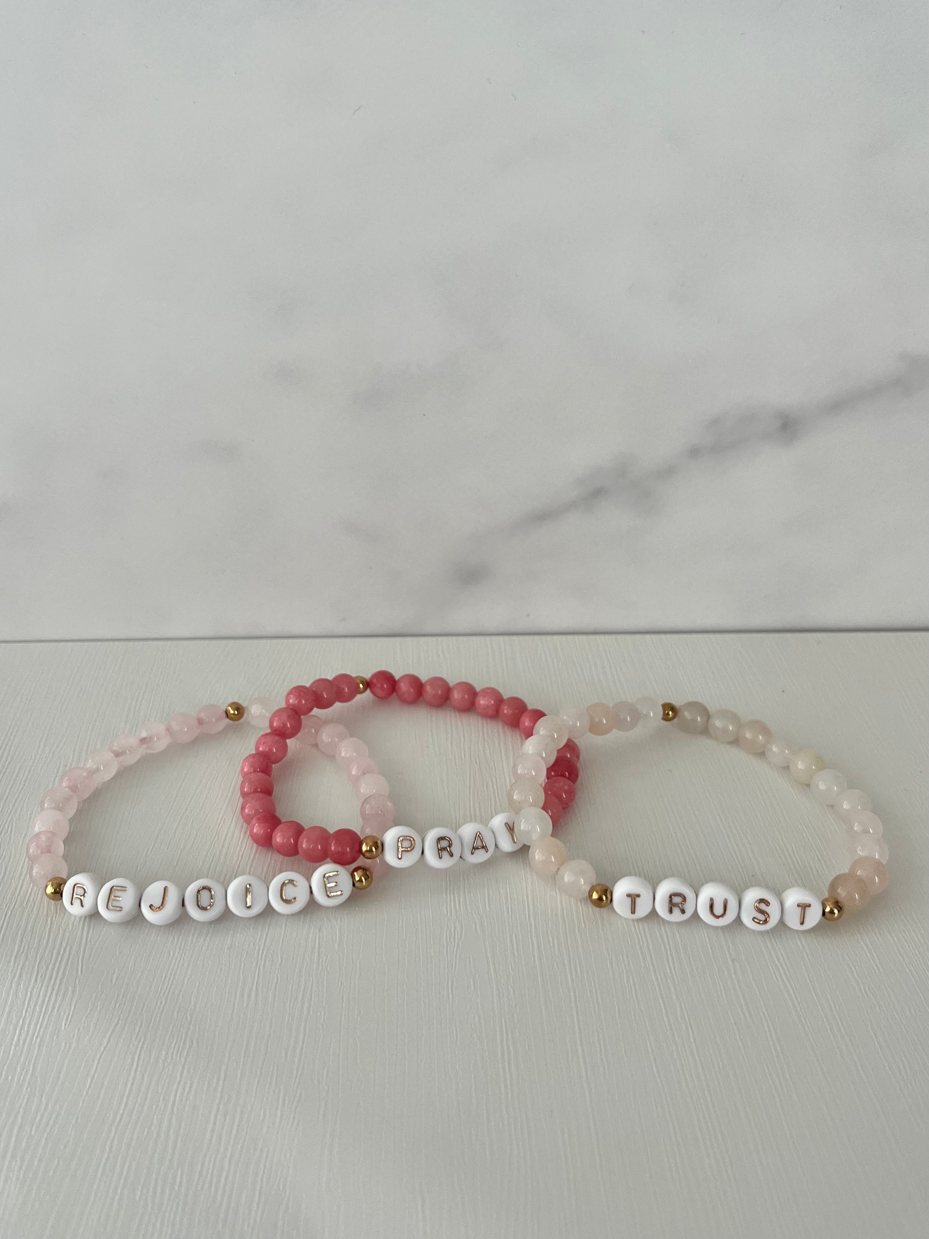 Beaded bracelet set with red PRAY, pink REJOICE, and cream TRUST beads