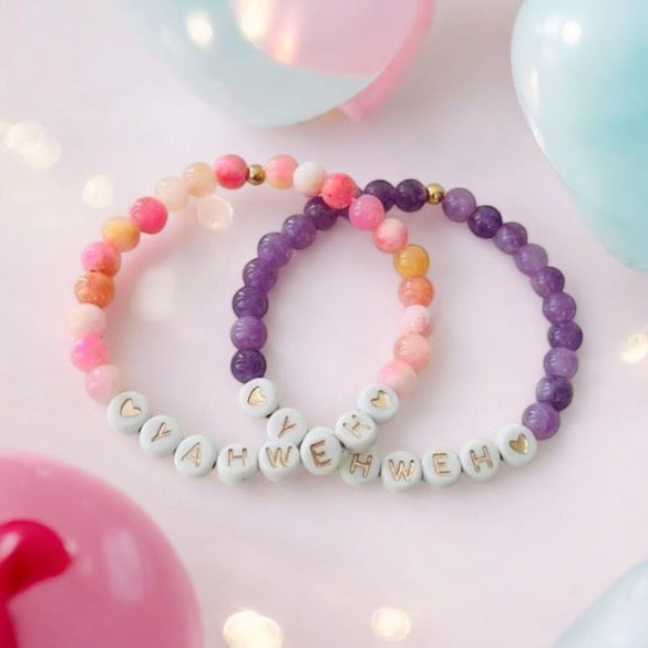Beaded stretch bracelet set with pink and purple beads, white letter charms spelling YAHWEH.