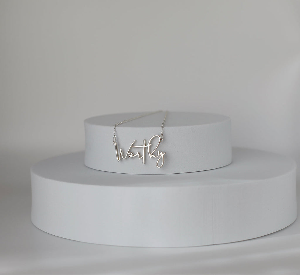 Sterling silver Worthy pendant necklace on tiered display platform
