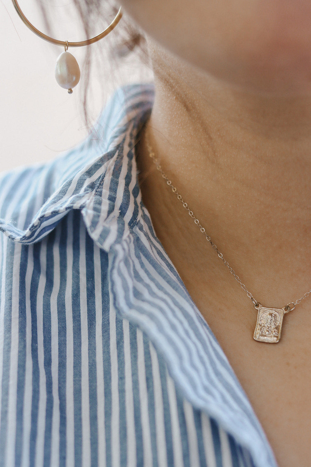Silver-tone scapular pendant necklace with small square medallion on delicate chain.
