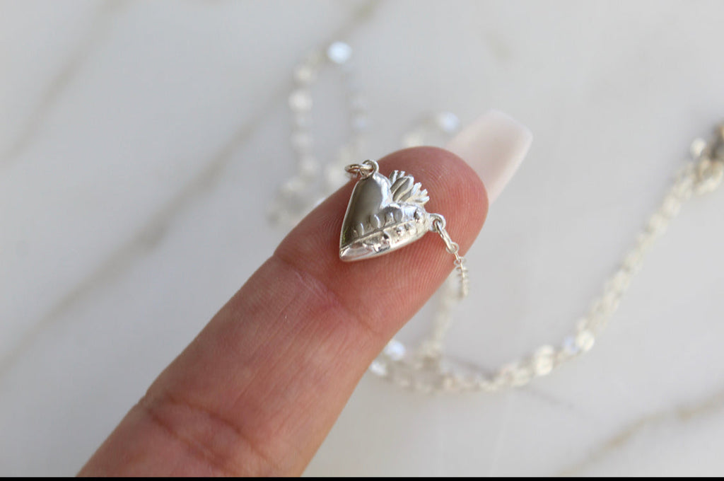 Sterling silver heart pendant necklace with textured heart face on a fine chain
