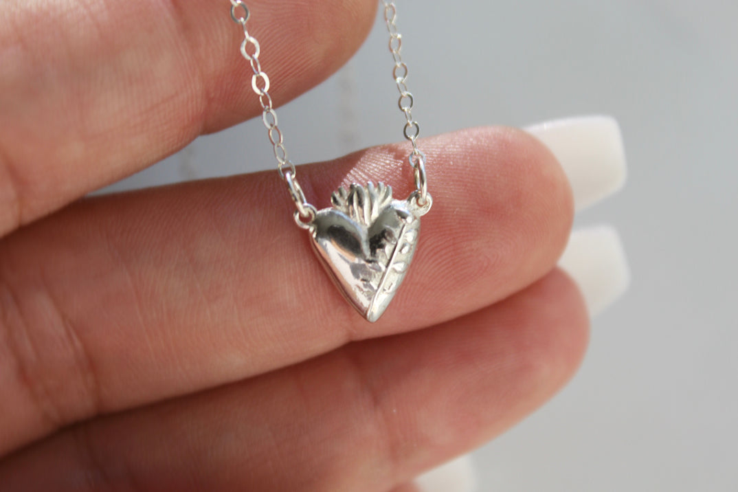 Sterling silver heart pendant necklace with raised floral details and link chain