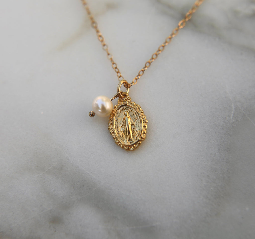 Gold-tone miraculous medal necklace with pearl bead and oval pendant on gold chain
