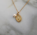 Gold-tone miraculous medal necklace with pearl bead and oval pendant on gold chain