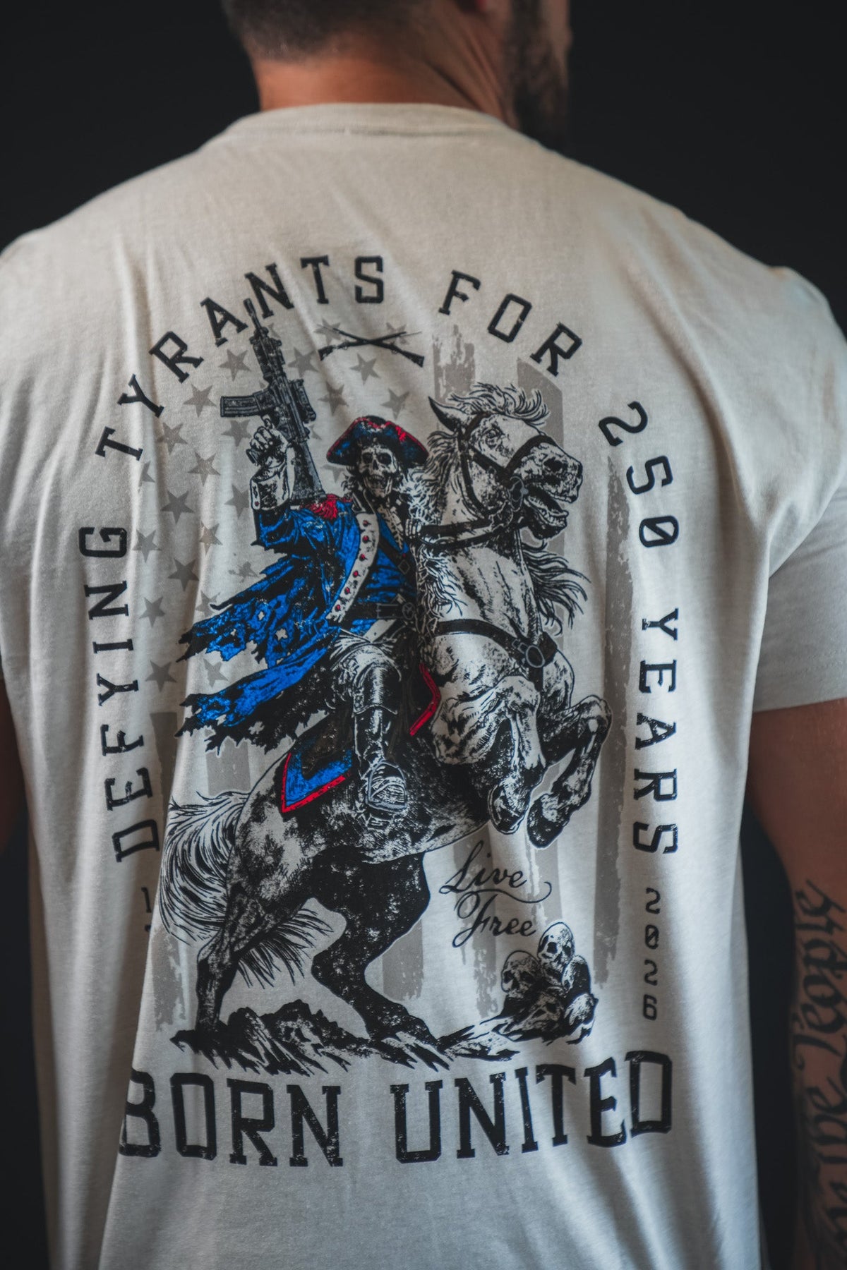 Light gray graphic back T-shirt with “Born United” headline and horse-and-rider artwork