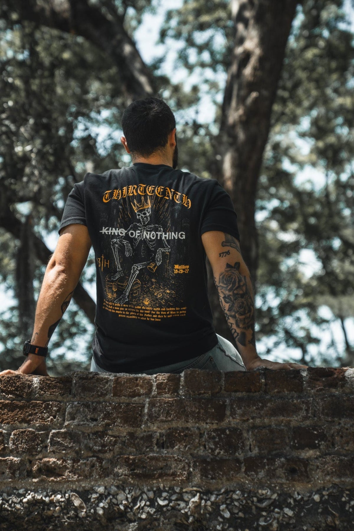 Black premium graphic tee with detailed back illustration and gold "13th" mark