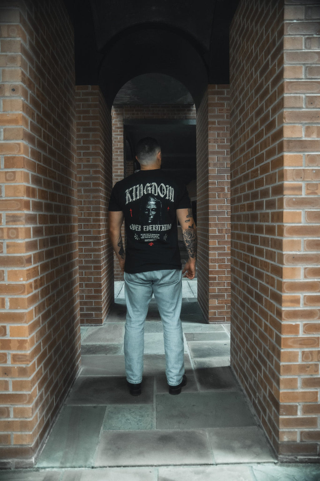Black crew-neck tee with full back graphic print, worn with light blue jeans