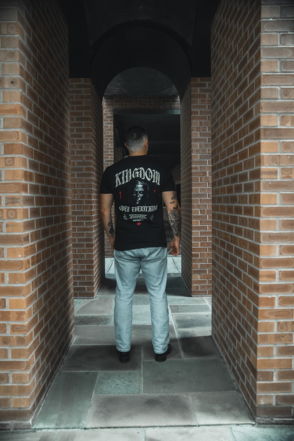 Black crew-neck tee with full back graphic print, worn with light blue jeans