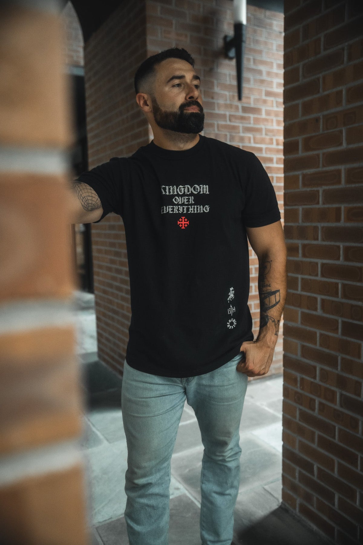 Black premium tee with centered chest graphic print, worn with light blue jeans